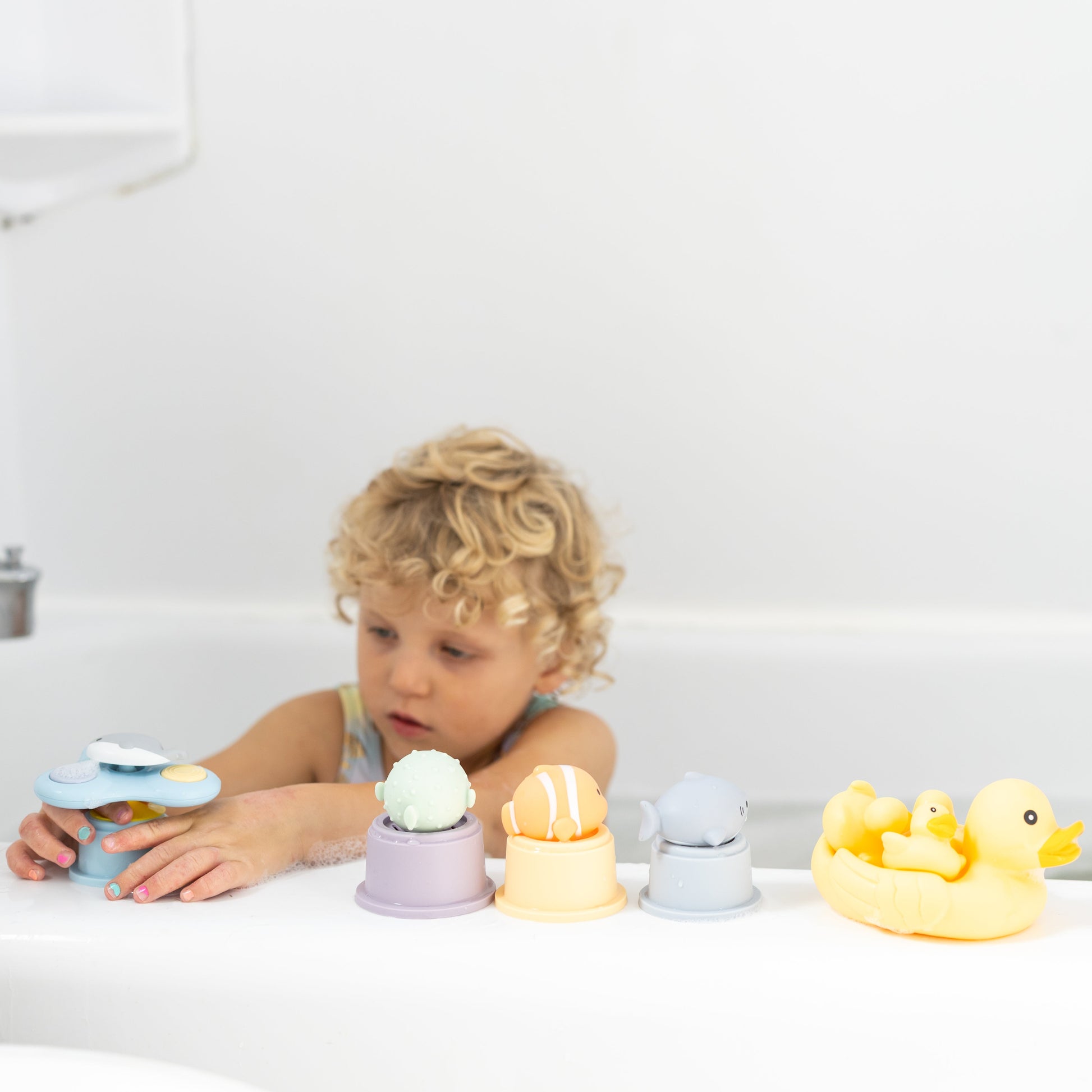 Child playing with bath toys in a bathtub