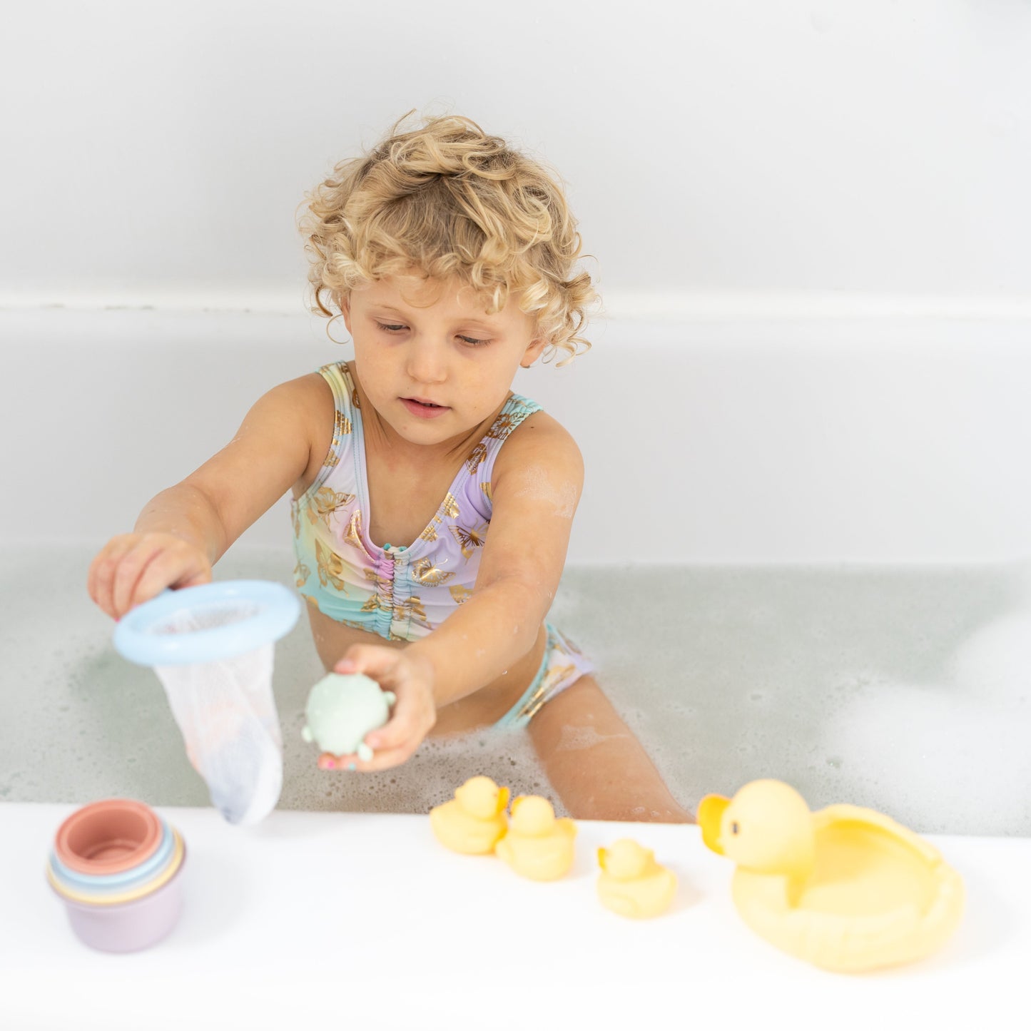 Child playing with bath toys in a bathtub