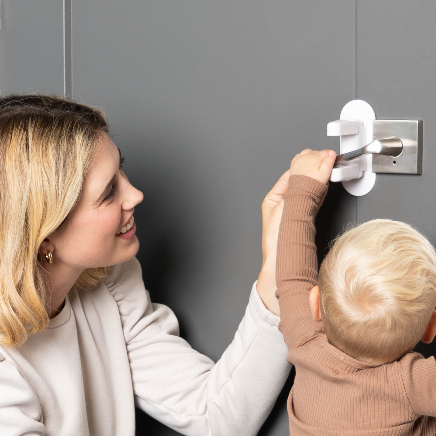 Mom showing toddler safety of door lever locks