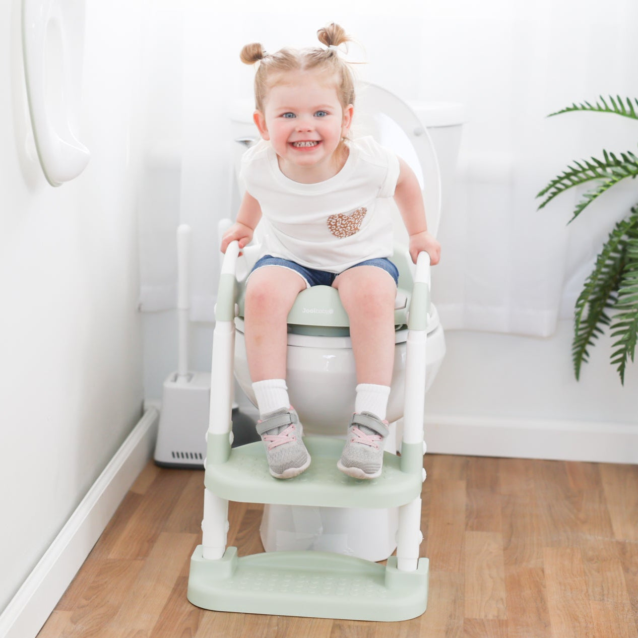 Toddler who is potty training using the potty ladder
