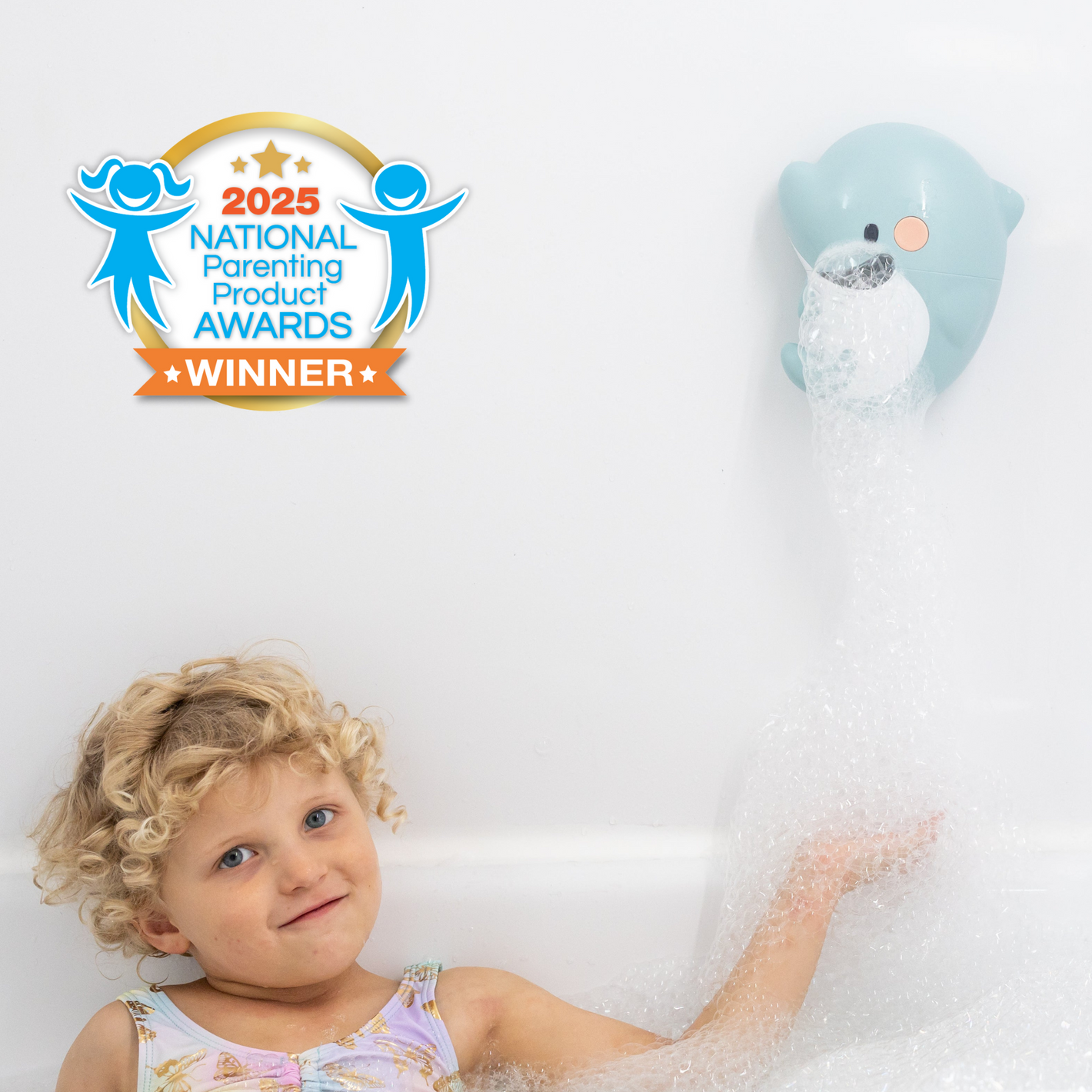 Child in bathtub playing with dolphin bubble maker