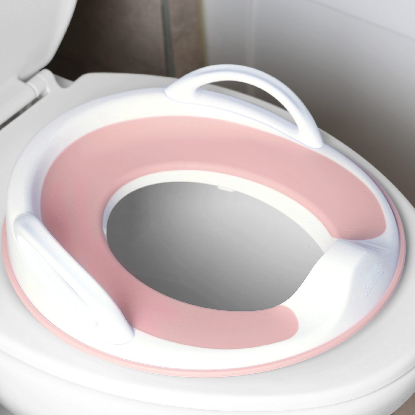 Jool Baby potty training seat with handles in pink on toilet