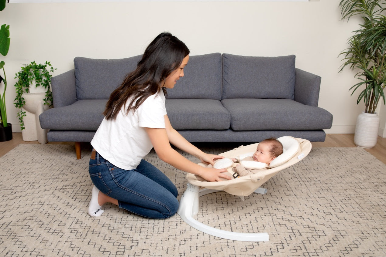 Mom playing with baby in Nova Signature Oatmeal baby swing.
