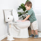 Child using a toilet with a seat up in a bathroom setting