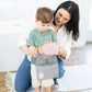Woman and child holding a gray bag with a logo on a wooden floor.