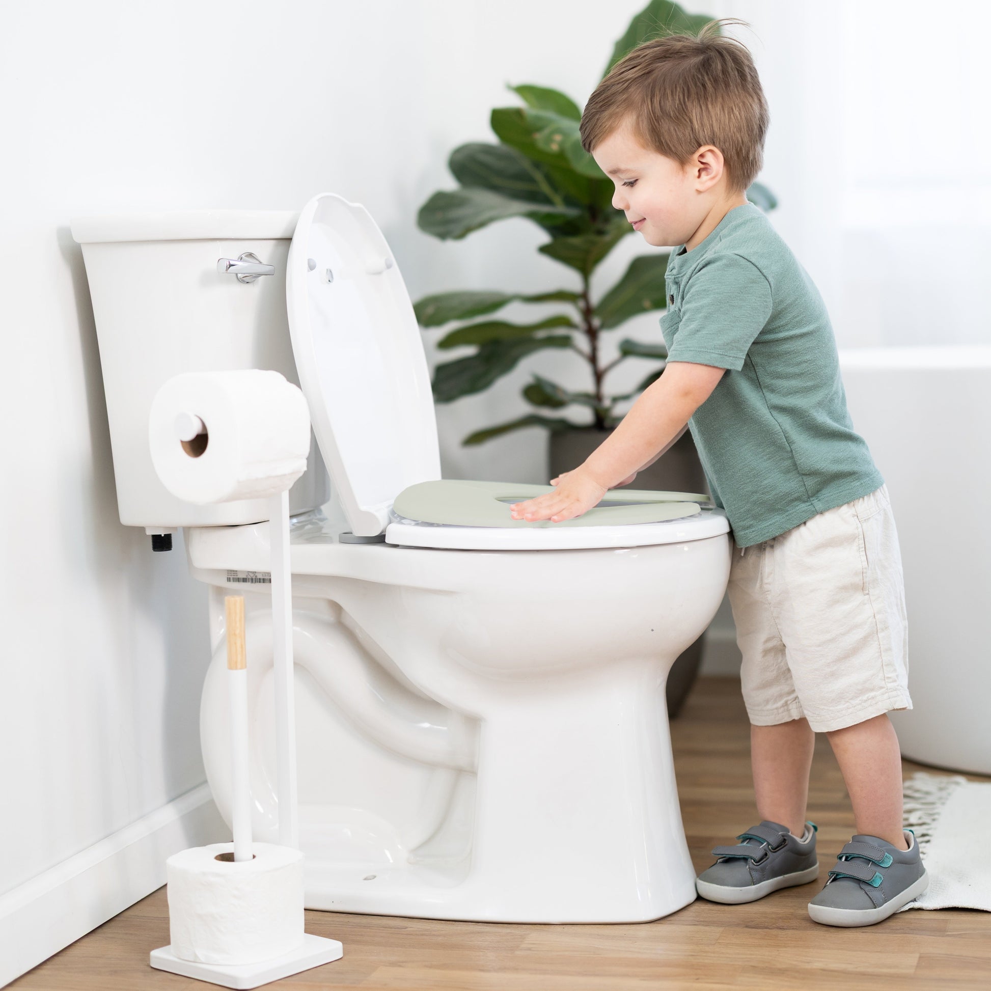 Child interacting with a toilet in a bathroom setting