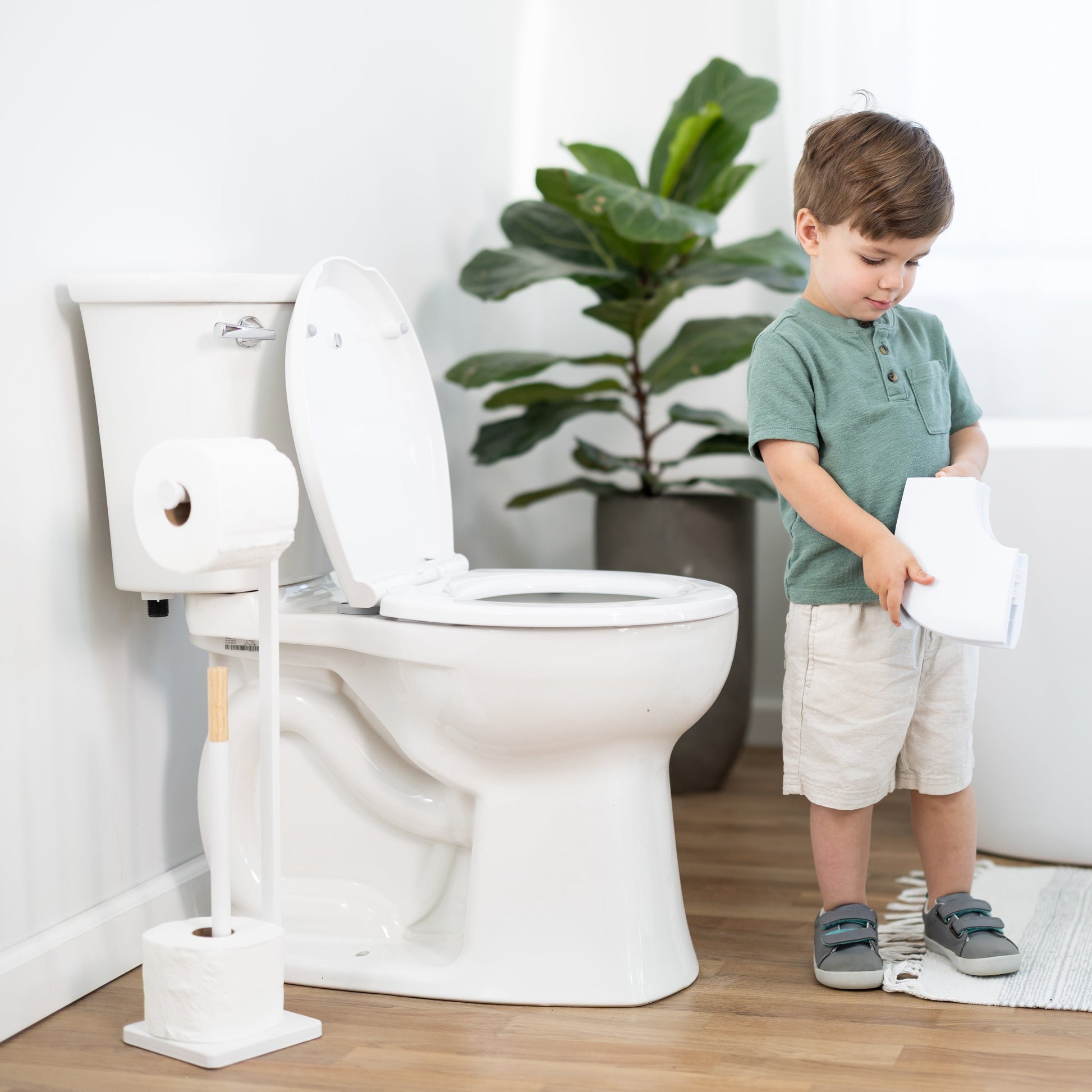 Child using passport folding potty seat in a bathroom setting