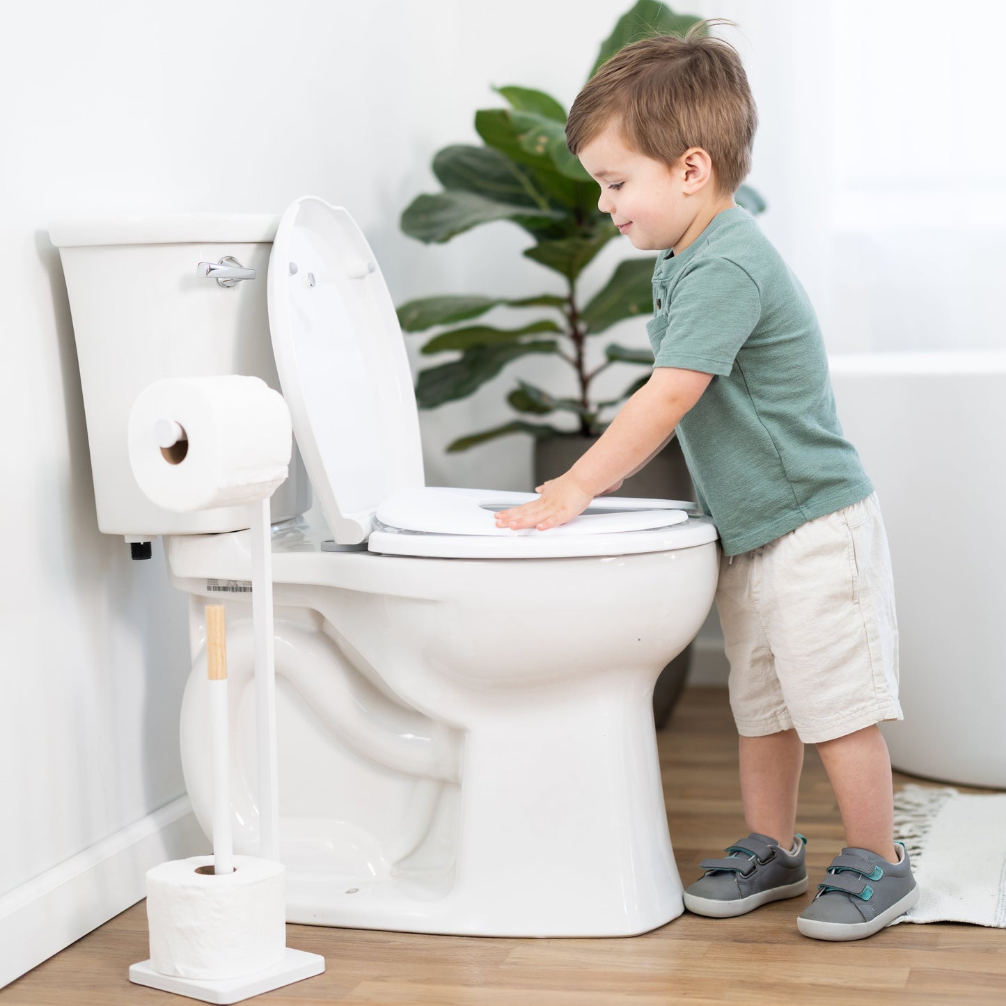 Child interacting with a toilet in a bathroom setting