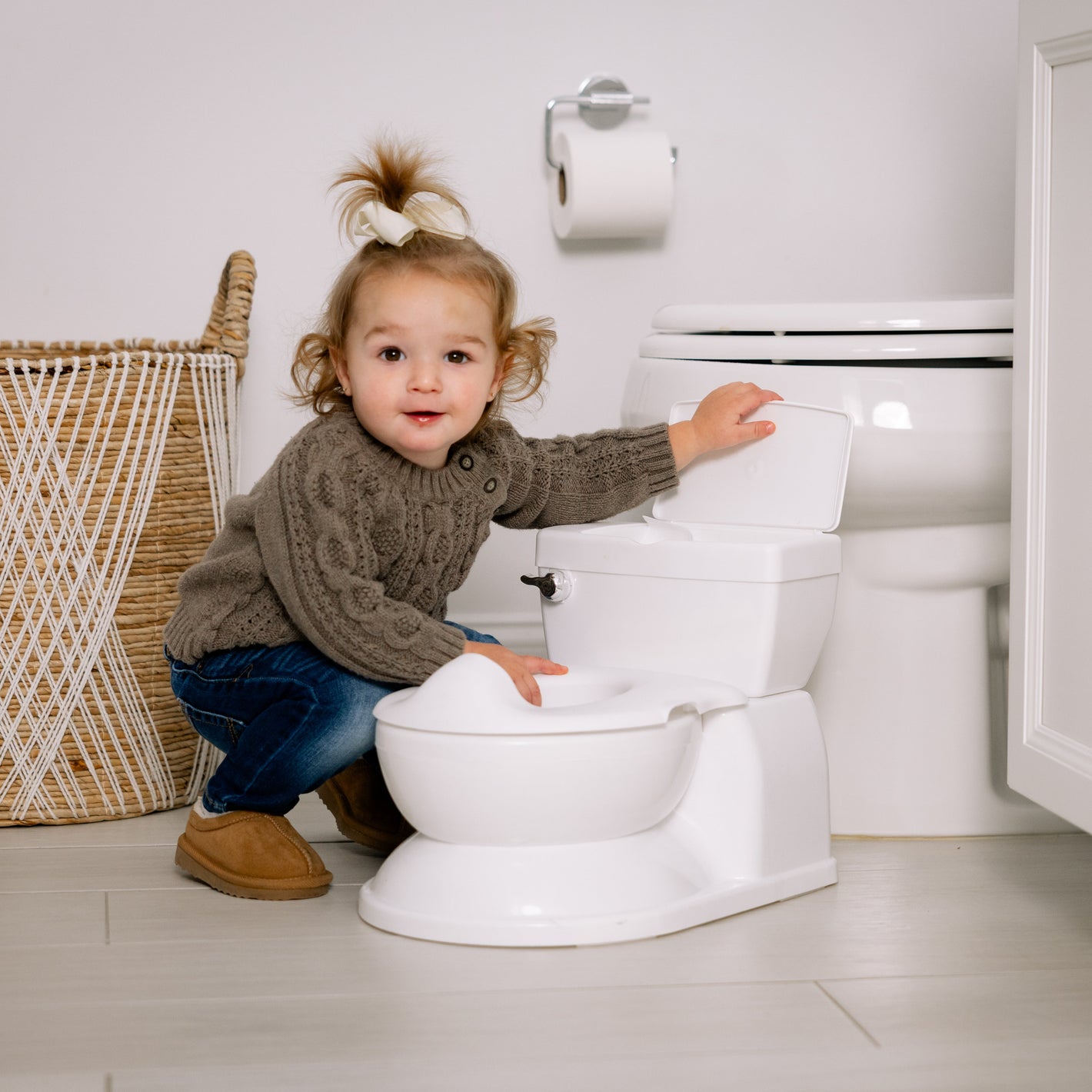 Child playing with a toilet in a bathroom setting