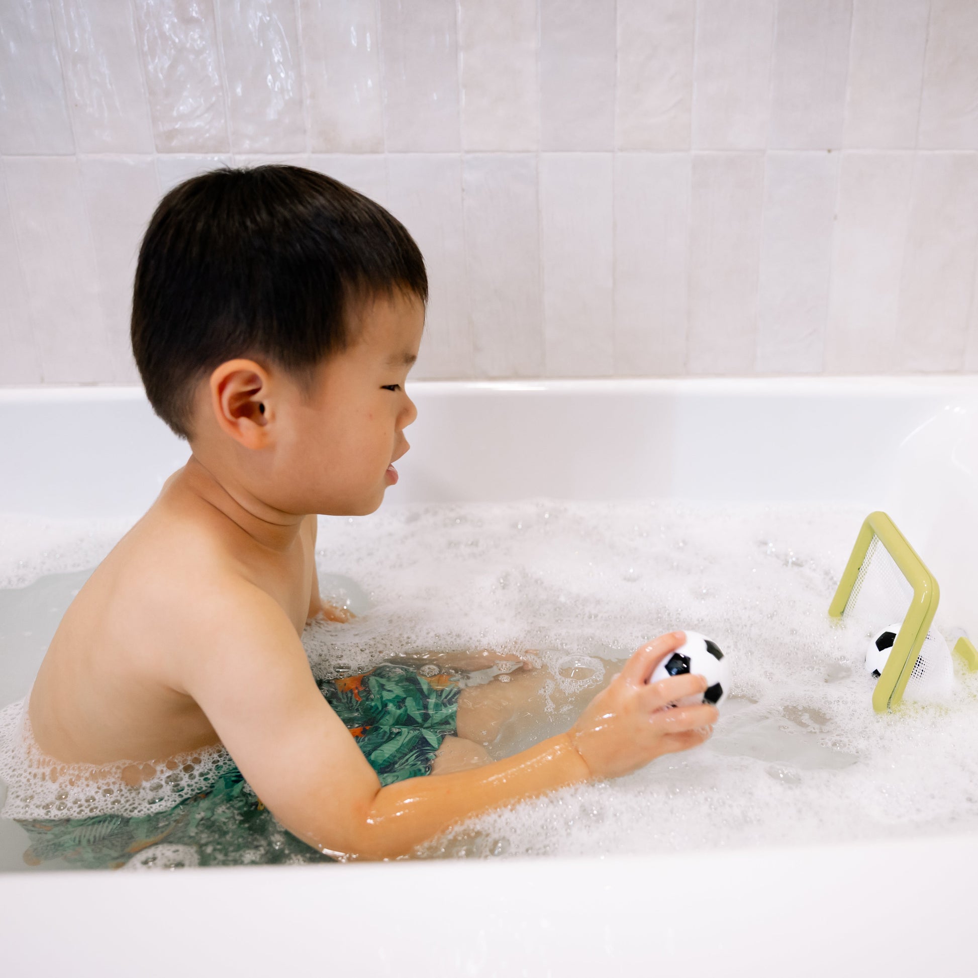 Child playing with a toy in a bathtub